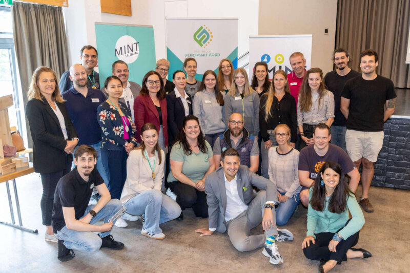 Gruppenfoto mit Partner:innen der MINT-Fair 2025, aufgenommen vor Roll-ups der beteiligten Organisationen.