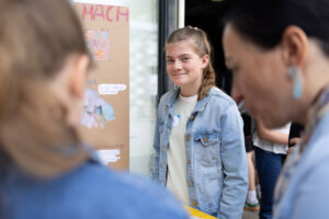 Eine Schülerin präsentiert ihr Projekt und beantwortet Fragen von Besucher:innen.